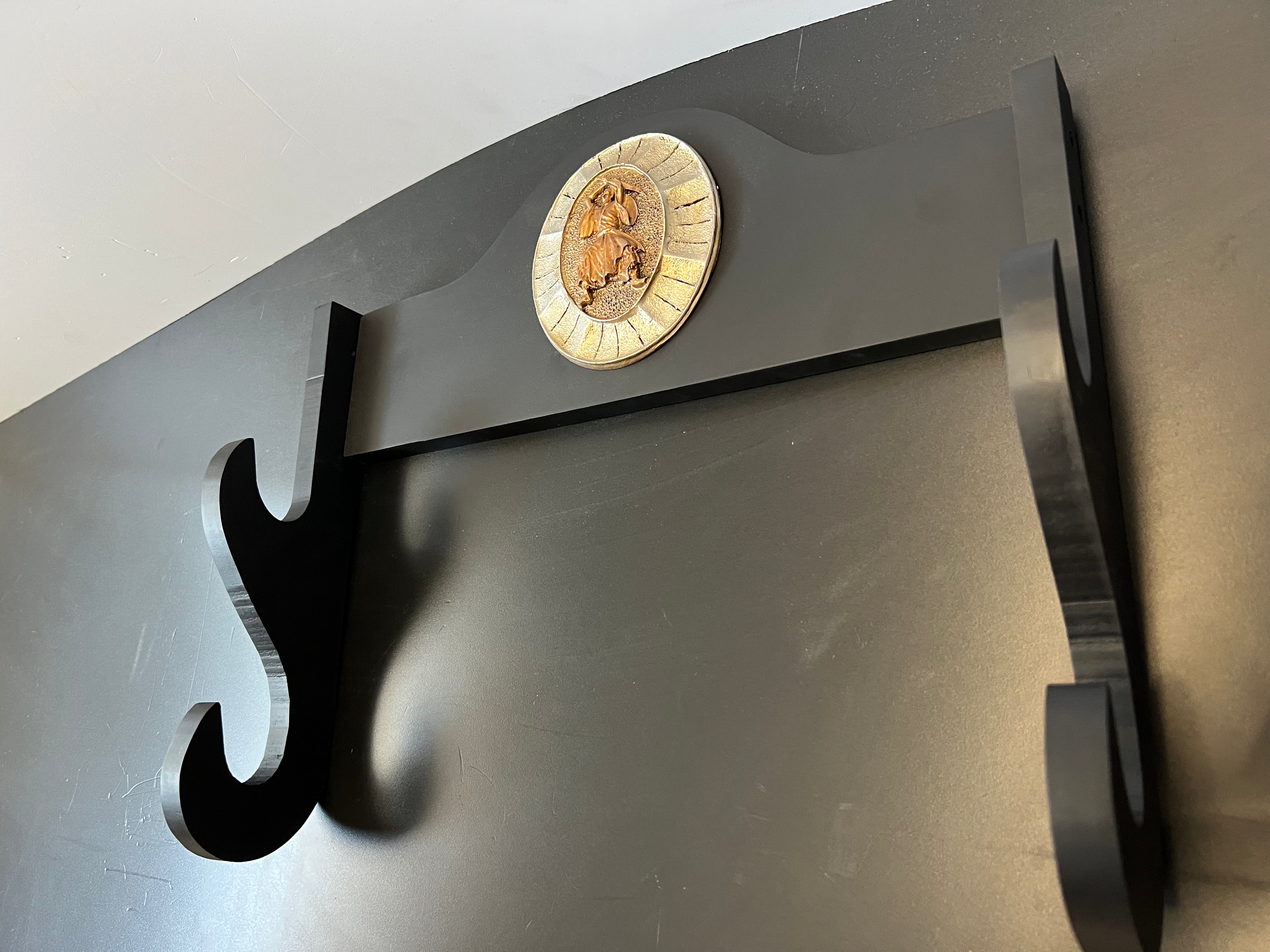 Eine Wandhalterung für 2 Katanas. Die Wandhalterung ist aus gebeiztem Holz und ist Schwarz. Die Wandhalterung hat zudem auch ein Emblem in der Mitte was die Wandhalterung zusätzlich sehr authentisch wirken lässt.